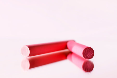 Red thick sticks of chalk on mirror background, beautiful chalk reflected in the mirror