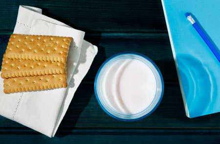 Glass of milk cookies and bookの写真素材