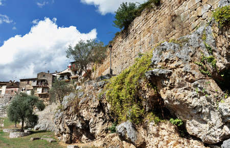 Ancient polygonal walls in Ferentino made with limestone blocks, in the background houses on ancient wallの写真素材