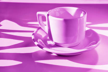White cup of coffee on pink background, long shadows on cup, break timeの写真素材