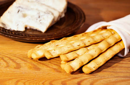 Breadsticks in white napkin and gorgonzola cheese on plate, ready to eatの写真素材