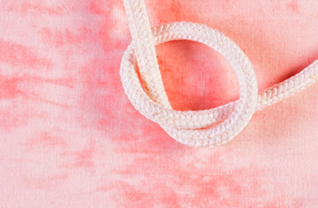 Tied white rope, against red background, nautical ropeの写真素材