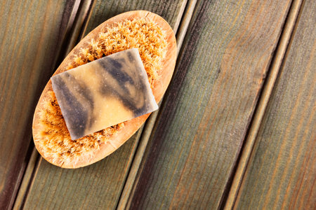 One bar of colored  soap  on bristle brush  on  wooden blue  background ,healthy lifestyleの写真素材
