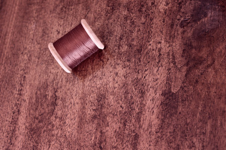 Spool of brown thread on wooden table, fashion industryの写真素材