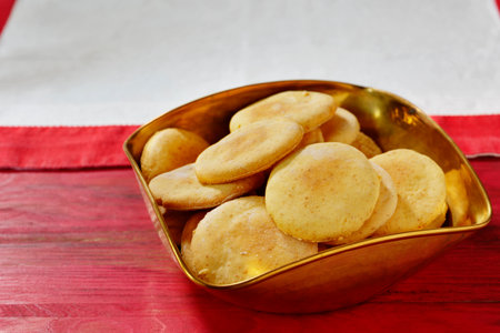 Homemade yellow cookies in bowl on wooden tableの写真素材