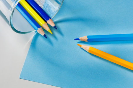 Pointed yellow and blue wooden pencils on yellow background, place of work or leisure timeの写真素材