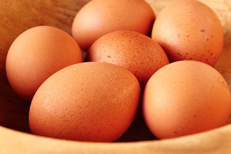Wooden bowl with fresh brown eggs, preparing food