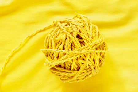 A ball of yellow twine on yellow background for work or leisure timeの写真素材