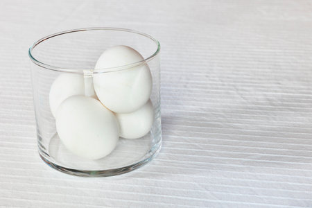 Glass bowl with fresh white eggs on table, preparing foodの写真素材