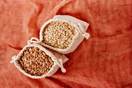 Uncooked pearl barley and spelt in bags, cereal grains ready for cookingの写真素材