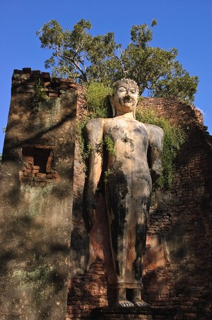 Ancient standing buddha image at Sukhothai Historical Park, Thailand.の写真素材