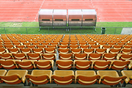 Coach and reserve benches with yellow seats in football stadium Back Perspective