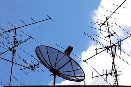 conceptual of satellite and antenna on blue skyの写真素材