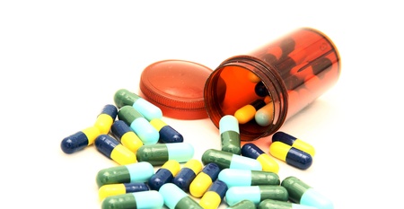 colorful capsule spilling out from pill boxの写真素材