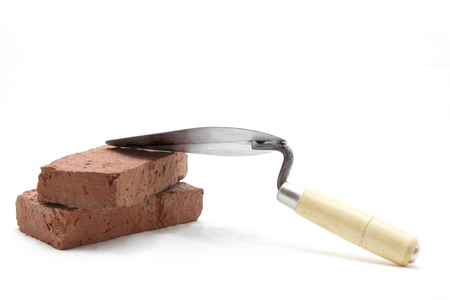 isolated of construction lute trowel with red brick on whiteの写真素材