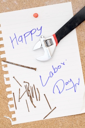 wrench and rusty nails with paper attach to cork board for labor dayの写真素材