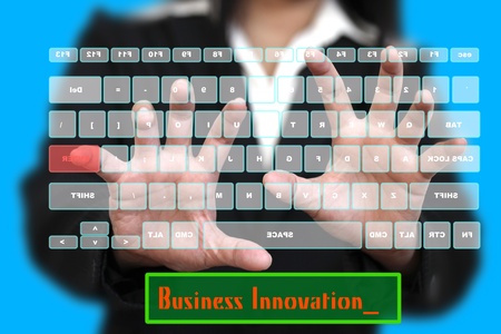 BusinessWoman typing Business Innovation on Virtual Keyboardの写真素材