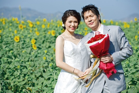 portrait of bride and groom on sunflower fieldの写真素材