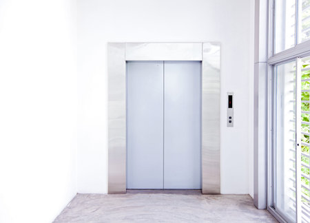 Front view of a modern elevator with closed doors in lobbyの写真素材
