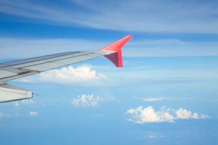Aircraft wing against bluesky from its windowsの写真素材