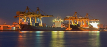 Panorama of Container Cargo freight ship with working crane bridge in shipyard at dusk for Logistic Import Export backgroundの写真素材