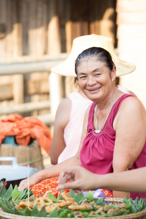 SUKHOTHAI, THAILAND - MAY 4: Unidentified mature woman is selling Thai traditional snack on May 4, 2013 at Rim Yom 2437 night market, Sukhothai, Thailand.のeditorial素材