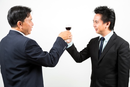Two businessmen cheering up with flutes of wineの写真素材