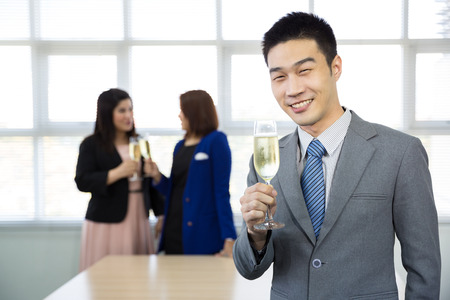 celebration of business people with champagne in a bright officeの写真素材