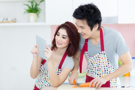 Couple in home domestic kitchen using tabletの写真素材