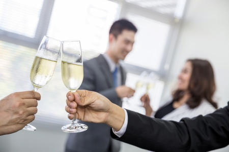 celebration of business people with champagne in a bright officeの写真素材
