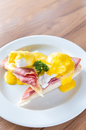 Eggs Benedict breakfast- toasted English muffins, ham, poached eggs, with buttery hollandaise sauceの写真素材