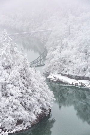 Winter landscape snow covered trees with River and Bridgeの写真素材