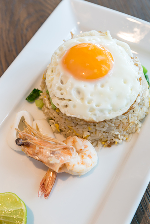 Seafood fried rice with squid and shrimp top with fried eggの写真素材