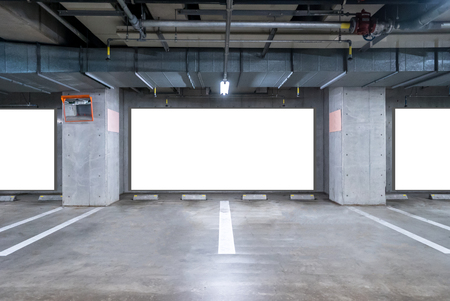 empty Parking garage underground with blank billboard, interior shopping mall at nightの写真素材