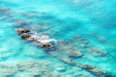 Top view of transparent shallow turquoise ocean sea water surface and rock at andaman sea indian...