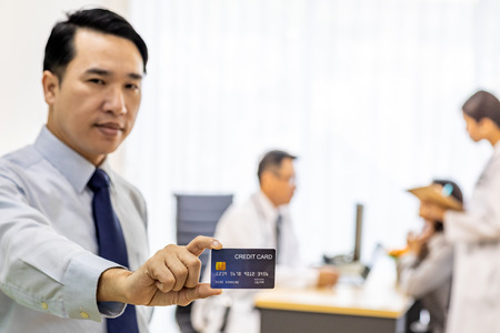 Portrait of Young adult Patient with credit card with examination room medical office background for insurance conceptの写真素材