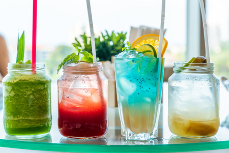 Variety of iced fruit juice cocktail and mock tail on glass tableの写真素材