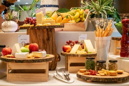 Variety of cheese with variety of fruit and cracker on wooden plate in buffet lineの写真素材