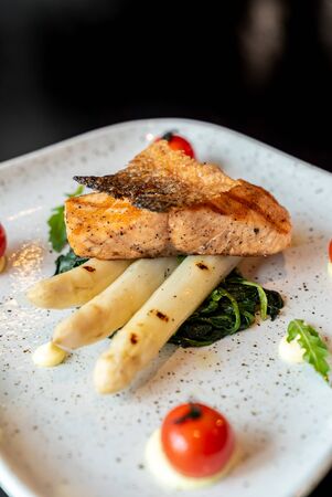 Grilled Salmon Fillet with grilled white asparagus serve with tomato and spinachの写真素材