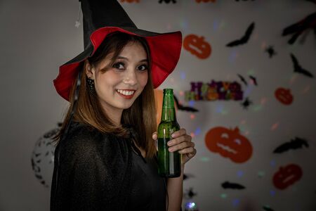 Young adult and teenager girl celebrating a Halloween party carnival Festival in Halloween costumes drinking alcohol beerの写真素材