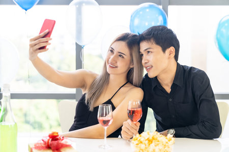 Young asian adult couple make selfie photographing for celebrating New Year and Christmas holiday...