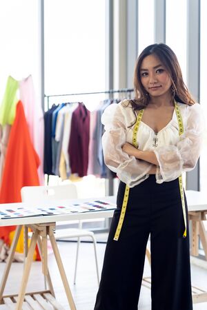 Portrait of young adult fashion designer as owner entrepreneur at her atelier studio. Using for entrepreneur startup concept.の写真素材