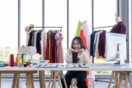 Portrait of young adult fashion designer as owner entrepreneur at her atelier studio. Using for entrepreneur startup concept.の写真素材