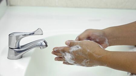 7 steps hand washing - Step 4/7 Interlace fingers and rub the back of fingers of both hands, protection from coronavirus COVID-19 infectionの写真素材