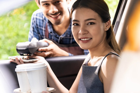 Asian woman customer make mobile payment contactless technology to waiter in drive thru food service...