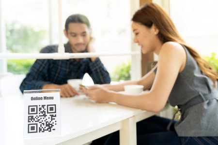 Asian customer looking online menu after scan QR code. Customer sat on social distancing table for...