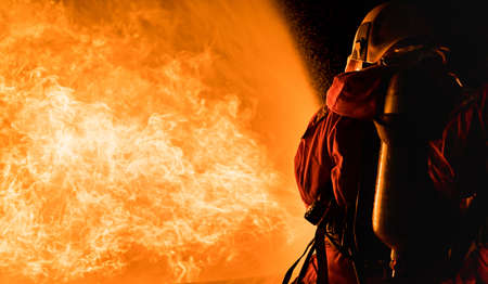 Firefighters using Twirl water fog type fire extinguisher to fighting with the fire flame from oil to control fire not to spreading out. Firefighter and industrial safety concept.の写真素材