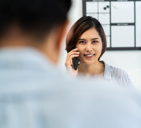 Businesswoman working and making a call in home office with social distance using screen partition...