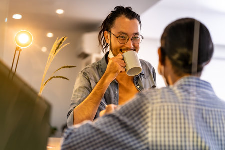 Two asian businessmen workers talking and discussion while coffee break bar at common zone of...