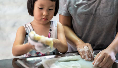 Asian girl washing dish and tableware with her mom, housework for child make executive function for kid. House-working  for kid lifestyle and family concept.の写真素材